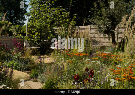 Vista della piantagione e area con posti a sedere nei quattro angoli del giardino RHS a Hampton Court Palace Flower Show 2013. Foto Stock