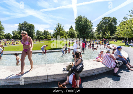 Le persone che si godono l'estate al Princess Diana Memorial Fountain, Hyde Park, Londra, Inghilterra, Regno Unito. Foto Stock