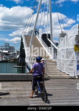 Dh Viaduct Basin Auckland Nuova Zelanda donna ciclista guardando Wynyard attraversando Te Wero bridge città in bicicletta escursioni in bicicletta Foto Stock