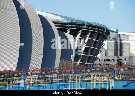 Il SSE Idro Arena sotto picchi di costruzione fuori da dietro il Clyde Auditorium (Armadillo) e la campana del ponte a Glasgow. Foto Stock