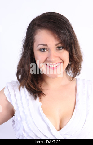 Molto graziosa adolescente in un abito bianco frilly top in un studio contro una luce colorata back-massa. Foto Stock