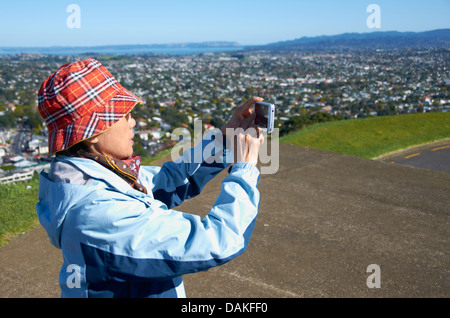 Turista giapponese di prendere una fotografia sulla sommità del monte Eden, Auckland, Nuova Zelanda. Foto Stock