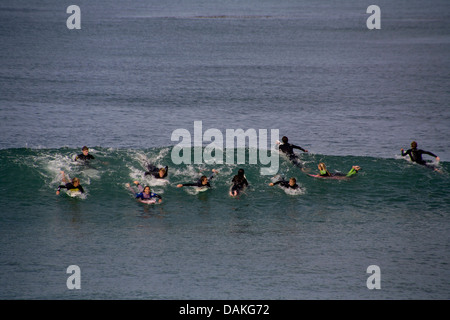 Teen un ragazzo e una ragazza soci del San Clemente, CA, Alta Scuola di surf pratica del team nella muta nelle fredde acque del Pacifico. Foto Stock