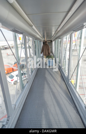 Imprenditori trascinando il suo trolley bag in aereo, Madrid, l' aeroporto di Barajas, Spagna Foto Stock