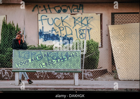 Un americano africano donna attende un bus in South Central Los Angeles dopo il 1992 Rodney King gara sommossa a Los Angeles. Foto Stock