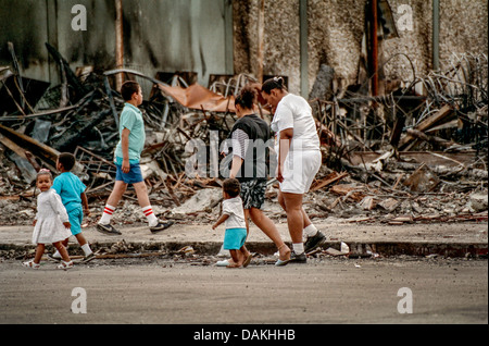 La gente del luogo di origine ispanica passato a piedi le rovine di un incendio negozio danneggiato in South Central Los Angeles dopo il 1992 Rodney King gara sommossa. Foto Stock