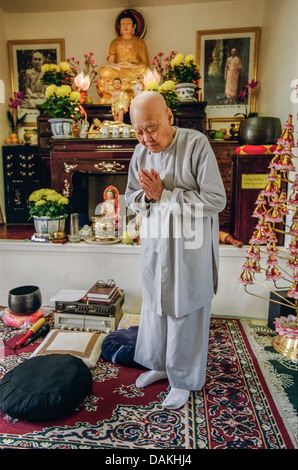 Un buddista vietnamita sacerdote pone nel suo tempio di fortuna si trova in una casa a Santa Ana CA. Foto Stock