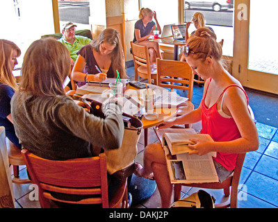 Alta scuola ragazze recuperare i loro compiti a Santa Barbara, CA, coffee shop Foto Stock