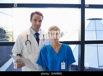 Medico e infermiere in piedi da una finestra Foto Stock