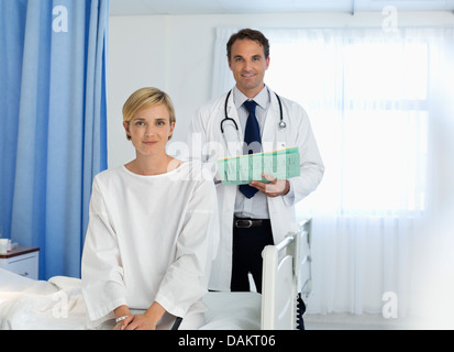 Il medico e il paziente sorridente in camera di ospedale Foto Stock