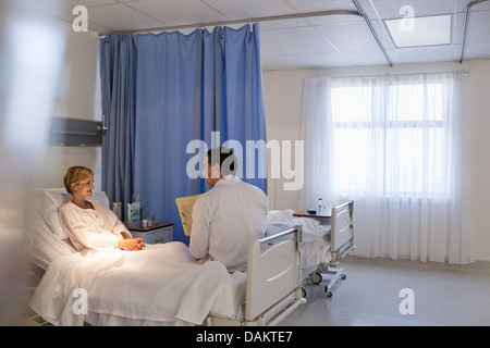 Medico di parlare con il paziente nella stanza di ospedale Foto Stock
