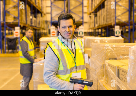 Lavoratore scatole di scansione in magazzino Foto Stock