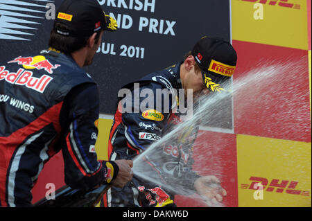 Tedesco di Formula Uno pilota Sebastian Vettel (R) di Red Bull celebra con il secondo posto il compagno di squadra Mark Webber da Australia sul podio dopo aver vinto il Gran Premio di Formula Uno di Turchia presso il circuito di Istanbul Park, al di fuori di Istanbul, Turchia, 08 maggio 2011. Foto: David Ebener dpa Foto Stock