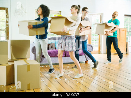 Gli amici di disimballare caselle nella nuova casa Foto Stock