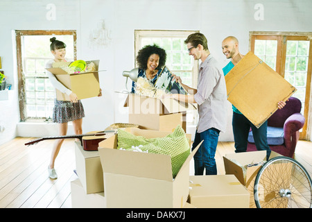 Gli amici di disimballare caselle nella nuova casa Foto Stock