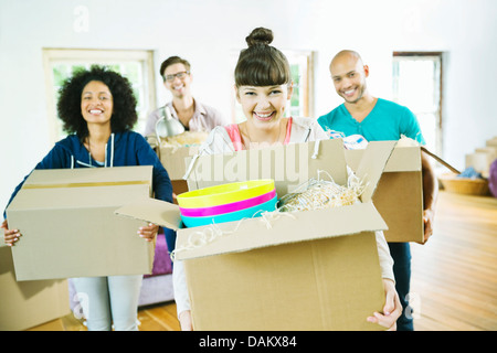 Gli amici di disimballare caselle nella nuova casa Foto Stock