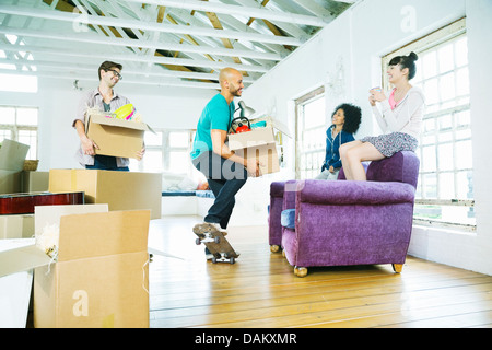 Gli amici di disimballare caselle nella nuova casa Foto Stock