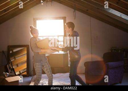 Giovane disimballaggio scatola in soffitta Foto Stock