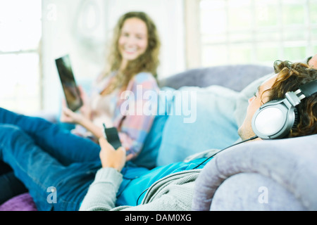 Giovani clienti di sesso femminile a piedi nudi la scelta di divano in  negozio mobili con cuscino Foto stock - Alamy