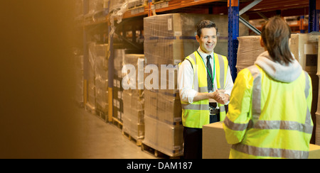 I lavoratori parlano in magazzino Foto Stock