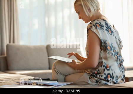 Donna che utilizza computer tablet sul divano Foto Stock