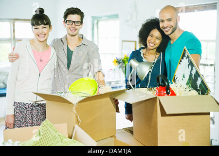 Gli amici di disimballare caselle nella nuova casa Foto Stock