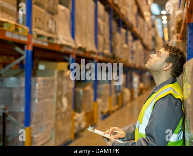 Lavoratore di caselle di controllo in magazzino Foto Stock