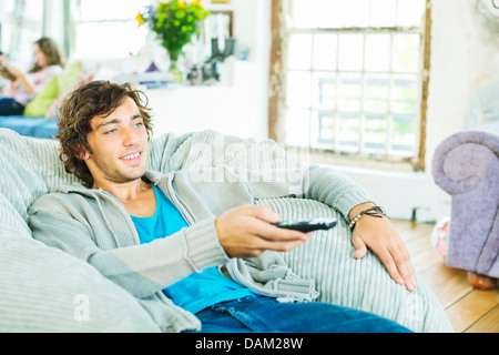 Uomo di guardare la televisione in sedia beanbag Foto Stock