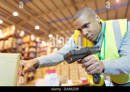 Lavoratore scatole di scansione in magazzino Foto Stock