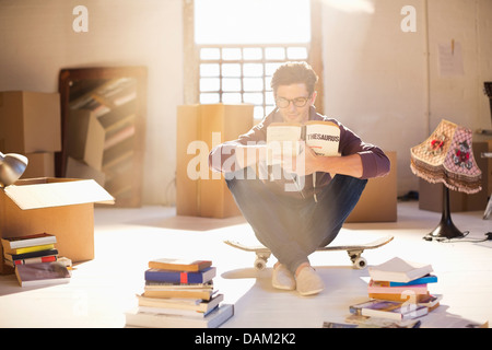 L'uomo la lettura nella nuova casa Foto Stock