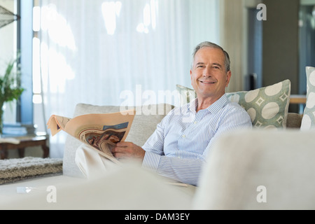 Uomo vecchio giornale di lettura sul divano Foto Stock