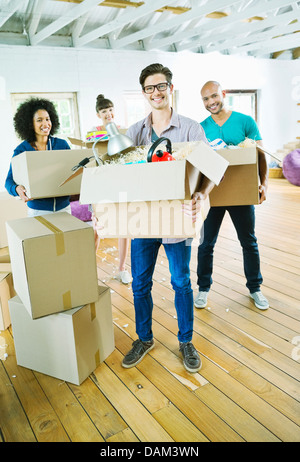 Gli amici di disimballare caselle nella nuova casa Foto Stock