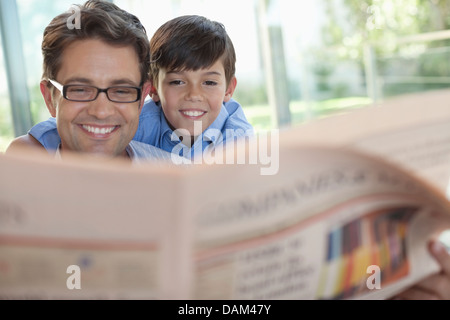 Padre e figlio leggendo il giornale insieme Foto Stock