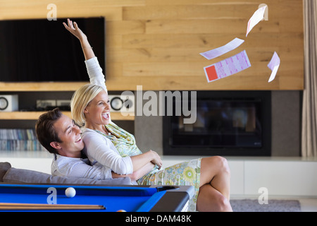 Donna tossing biglietti della lotteria nel soggiorno Foto Stock