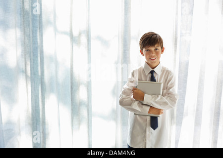 Ragazzo in camicia e cravatta azienda computer tablet Foto Stock