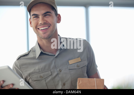 Ragazzo delle consegne sorridente con il pacchetto Foto Stock