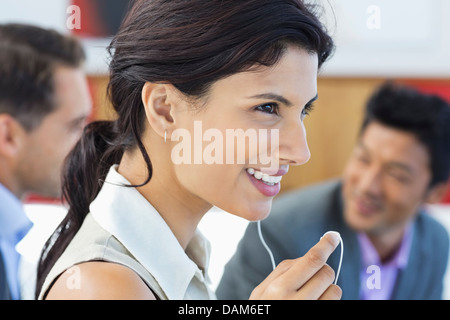 Imprenditrice parlando su auricolare in carica Foto Stock