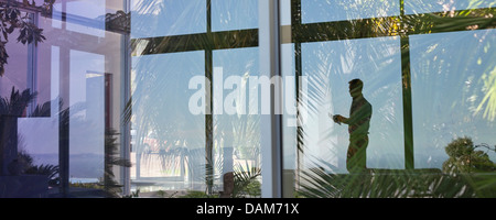 La riflessione di imprenditore nella finestra Foto Stock