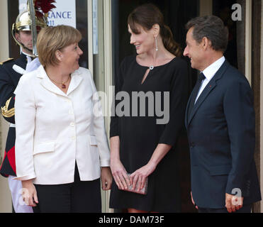 Der französische Präsident Nicolas Sarkozy und seine Frau Carla Bruni-Sarkozy (M) begrüßen Bundeskanzlerin Angela Merkel (CDU) am Donnerstag (26.05.2011) a Deauville. In dem französischen Seebad am Ärmelkanal findet am 26. und 27. Mai der diesjährige G8-Gipfel statt. Foto: Peer Grimm dpa Foto Stock