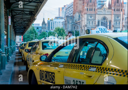 Taxi linea fino a Flinders Street stazione ferroviaria nel centro di Melbourne, in attesa di passeggeri. Foto Stock