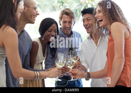 Gli amici la tostatura a vicenda con champagne Foto Stock