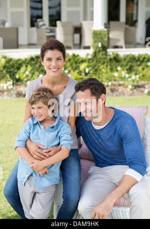 Famiglia sorridente al di fuori casa Foto Stock