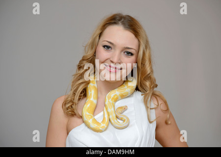 Sfera di python, royal python (Python regius), bellezza donna giovane con un pitone intorno al collo Foto Stock