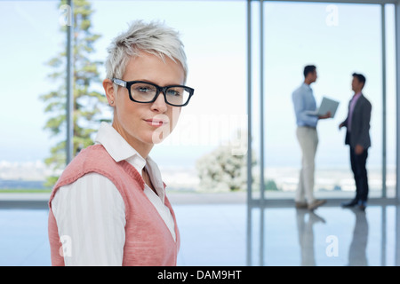 Imprenditrice in piedi in ufficio Foto Stock