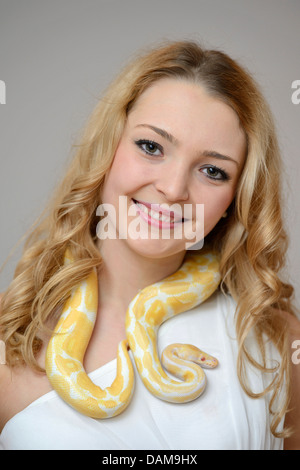 Sfera di python, royal python (Python regius), bellezza donna giovane con un pitone intorno al collo Foto Stock