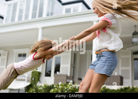 Madre e figlia giocando fuori casa Foto Stock