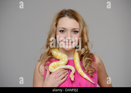 Sfera di python, royal python (Python regius), bellezza donna giovane con un pitone intorno al collo Foto Stock