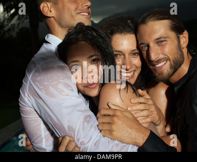 Sorridente abbracciando amici all'aperto Foto Stock