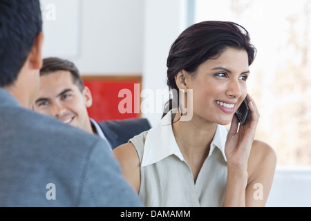 Imprenditrice parlando al cellulare in ufficio Foto Stock