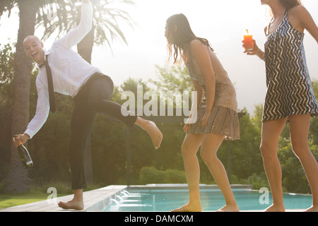 Amici avente le bevande con piscina Foto Stock